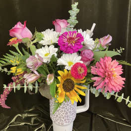 Mixed bouquet in a leopard-print tumbler with pink, white, and yellow flowers