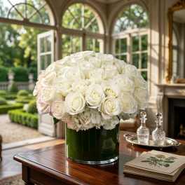 White rose and hydrangea arrangement in a dark green vase