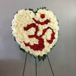 Heart-shaped floral wreath of white and red flowers on a stand