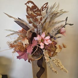 Autumn floral arrangement with a bird topper in a textured vase