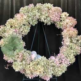 Pastel hydrangea wreath with a green bow and small bird ornament