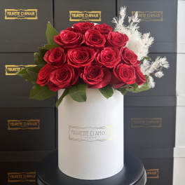 Red roses arranged in a white hat box with white filler flowers