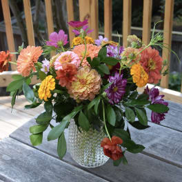 Mixed bouquet of colorful flowers in a clear glass vase