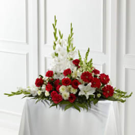 Red and white floral centerpiece on a draped table