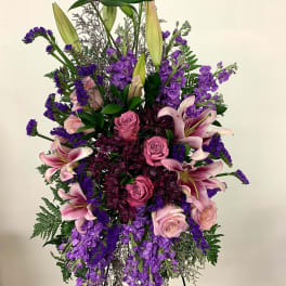 Tall standing arrangement of pink and purple flowers with lilies and roses