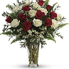 Red and white roses arranged in a clear glass vase