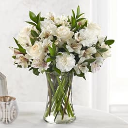 White roses and alstroemeria in a clear glass vase