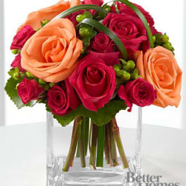 Bouquet of pink and peach roses in a clear glass vase
