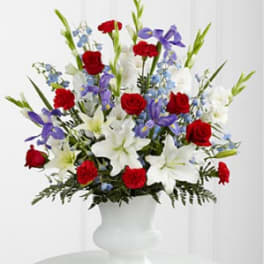 Red roses, white lilies, and purple flowers in a white vase