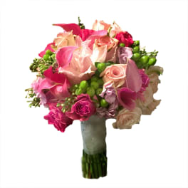 Bouquet of pink and peach roses with green berries in a wrapped handle