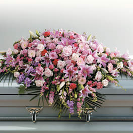 Pink and white floral casket spray with lilies and roses