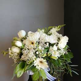 White mixed bouquet in a glass vase with gerbera daisies and tulips