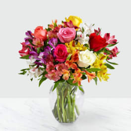 Mixed bouquet of roses and alstroemeria in a clear glass vase