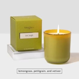 Green candle in a glass jar beside its box