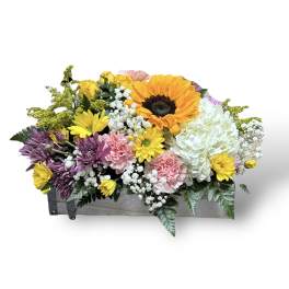 Mixed bouquet in a wooden box with sunflowers, roses, hydrangea, and daisies