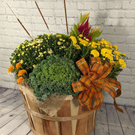 Fall flower arrangement in a wooden basket with yellow and orange blooms