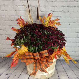 Fall flower basket with burgundy mums, faux leaves, and a plaid ribbon