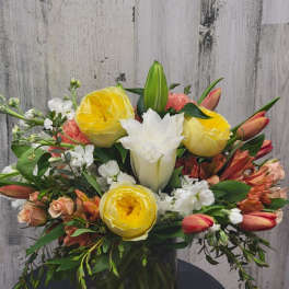 Mixed bouquet of yellow and white flowers in a glass vase