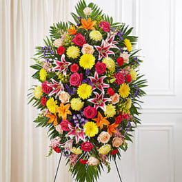 Large standing spray of mixed flowers in bright colors on an easel
