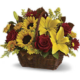 Basket arrangement with yellow lilies, sunflowers, red roses, and mums