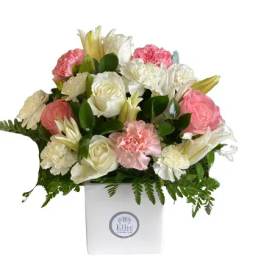 Pink and white floral arrangement in a white box