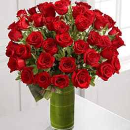 Bouquet of red roses in a tall glass vase