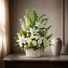White lilies and roses arranged in a white basket