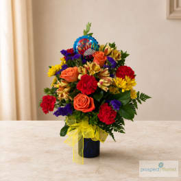 Colorful mixed bouquet in a blue vase with a birthday balloon