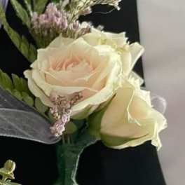 Boutonniere with cream roses and small pink filler flowers