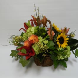 Basket arrangement with sunflowers, lilies, and roses