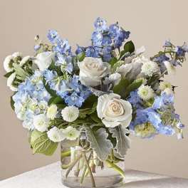 Blue and white flower arrangement in a clear glass vase