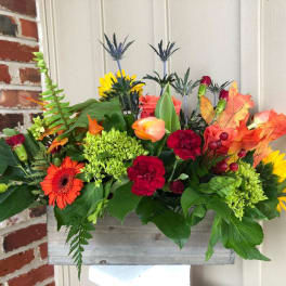 Colorful mixed flower arrangement in a rustic wooden box