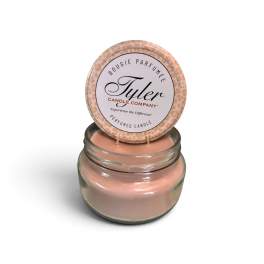 Pink scented candle in a glass jar with a labeled lid