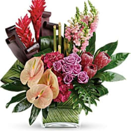 Tropical floral arrangement with pink roses and anthuriums in a glass vase
