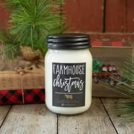 White jar candle with a black lid and Christmas label