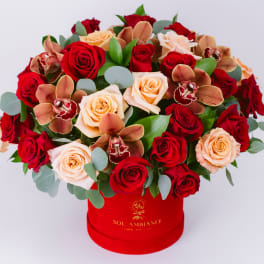 Red and peach roses with orchids in a red hat box