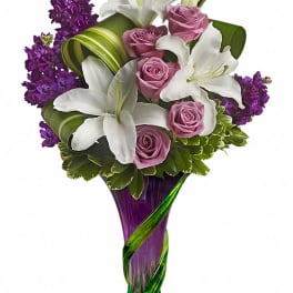 Bouquet of white lilies and pink roses in a purple glass vase