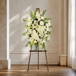 White floral arrangement on a wooden easel stand