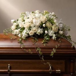White floral casket spray with roses and trailing ivy