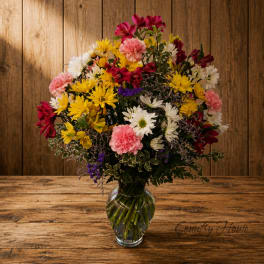 Mixed bouquet of daisies, carnations, and alstroemeria in a glass vase