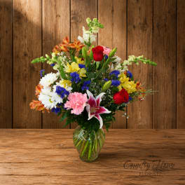 Mixed bouquet of colorful flowers in a clear glass vase