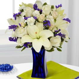 White lilies and roses in a blue glass vase