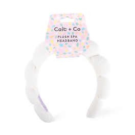 White plush spa headband with a pastel patterned tag