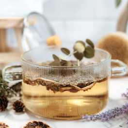 Glass mug with tea and dried citrus slices on a table