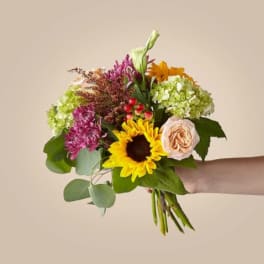 Handheld bouquet with sunflowers, hydrangeas, and roses