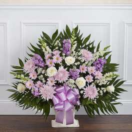 Lavender and white floral standing spray with a purple ribbon