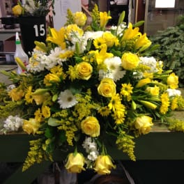 Yellow and white floral arrangement with roses and lilies
