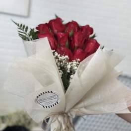 Bouquet of red roses wrapped in cream paper