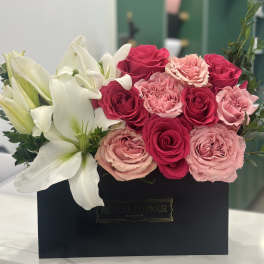 Pink and white roses with white lilies in a black box