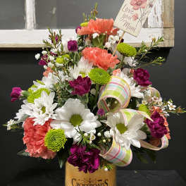 Mixed bouquet in a candle jar with a "Love you Mom" card